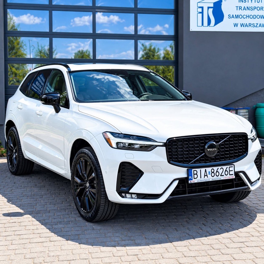 Biały Volvo XC60 z czarnym dachem, sfotografowany przed budynkiem studia